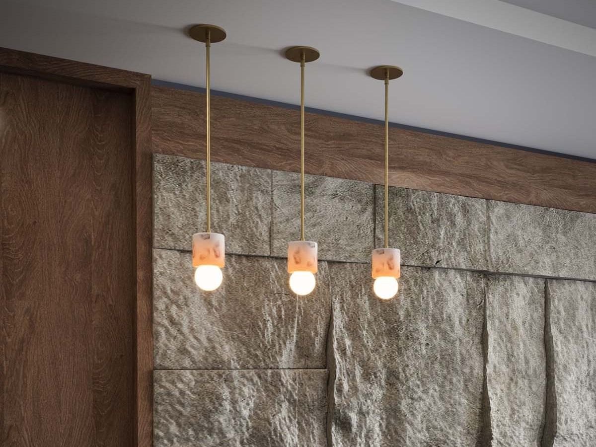Pendant trio over a stone wall in a hotel lounge